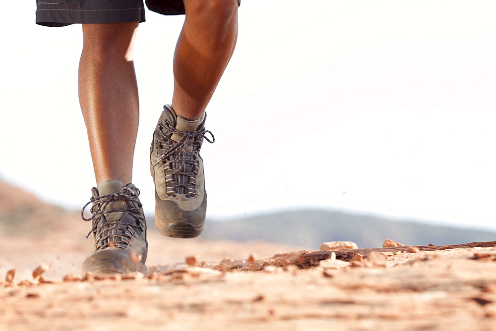 Hiking boots moving across rocky surface