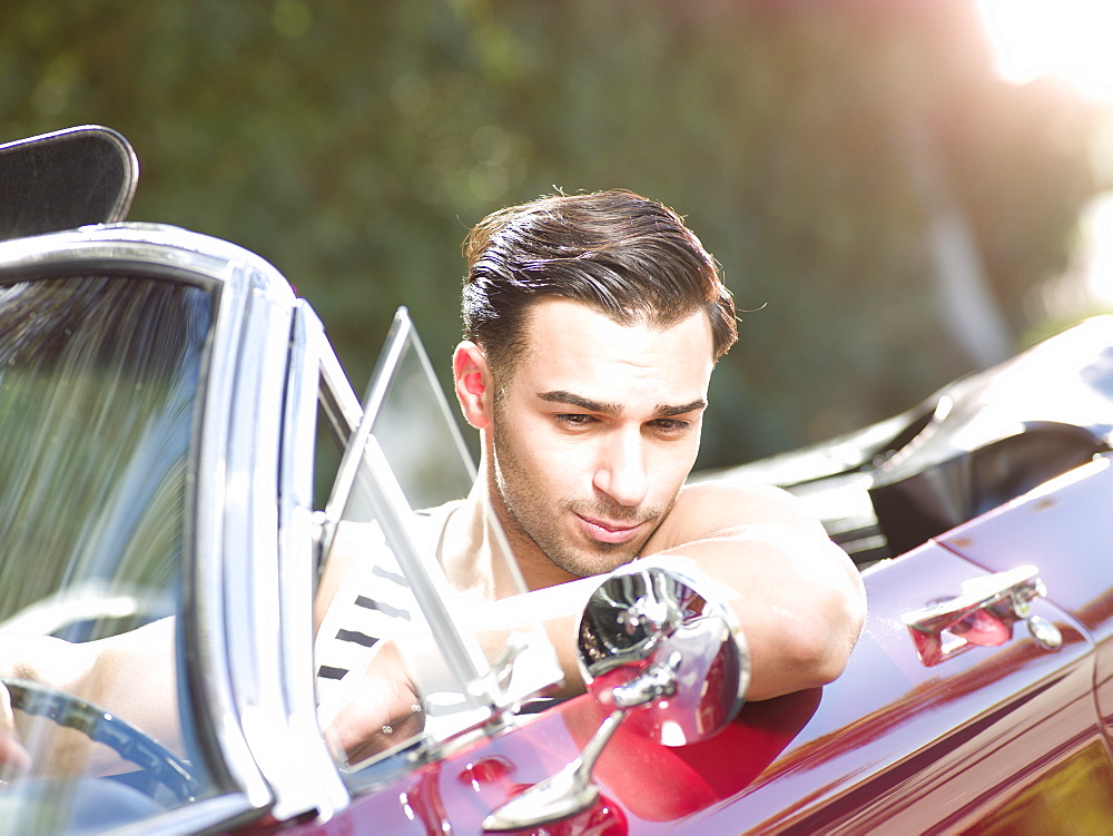Smiling young man in convertible car
