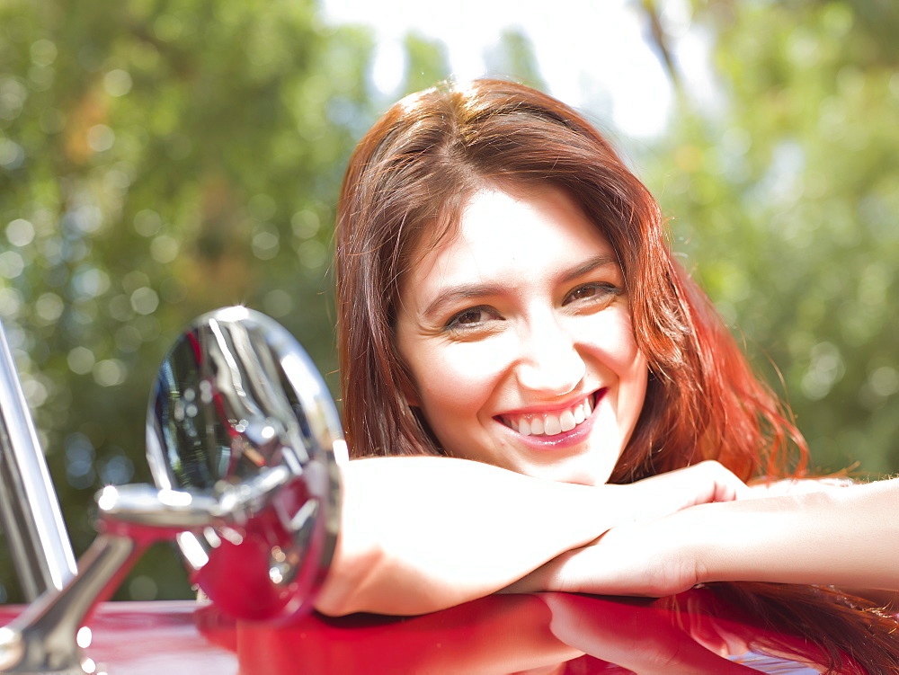 Smiling young woman in convertible car