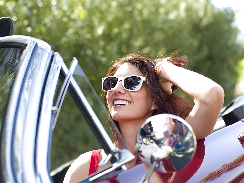Smiling young woman in convertible car