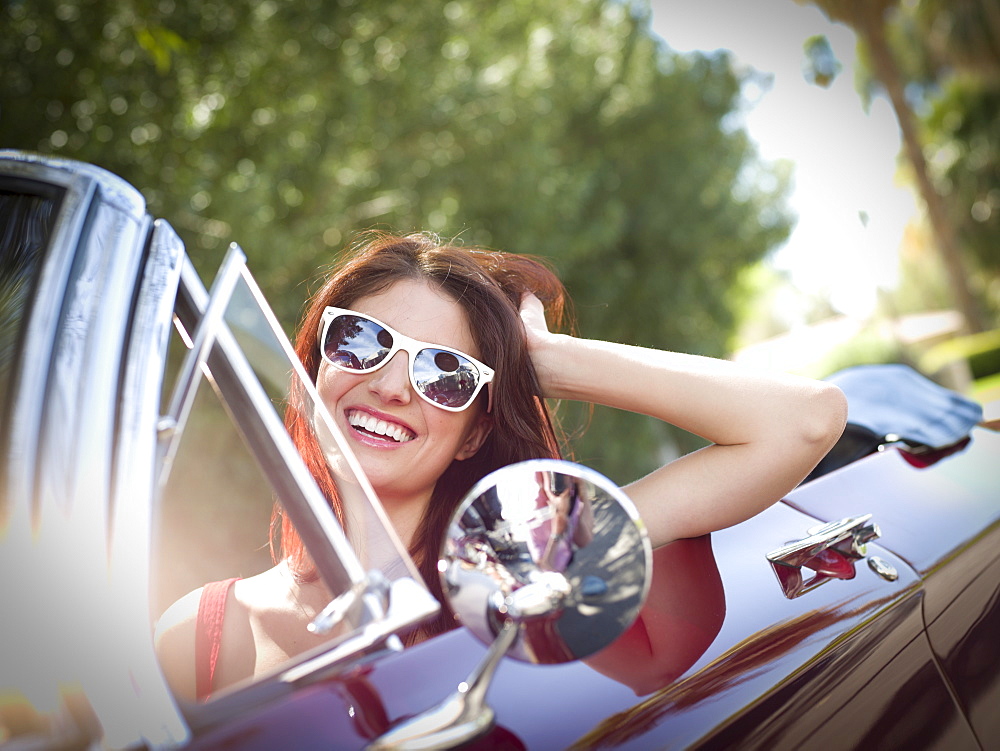 Smiling young woman in convertible car