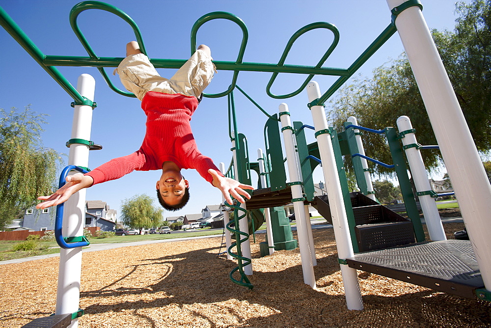 USA, California, Boy (12-13) climbing at playground