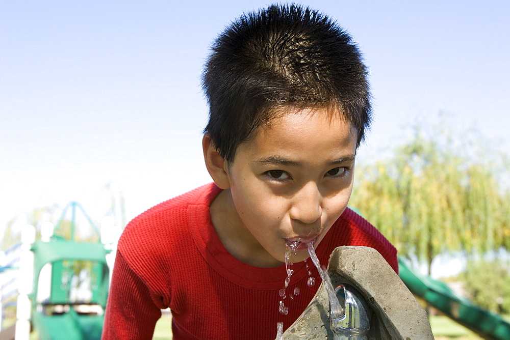 Boy (12-13) at drinking fountain