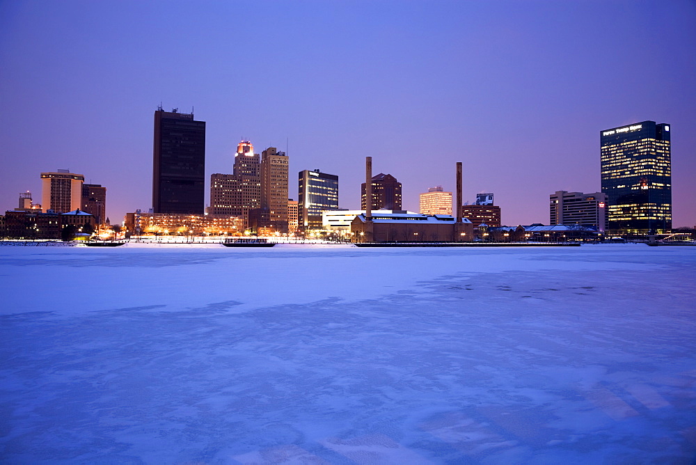 USA, Ohio, Toledo skyline across frozen river, dusk