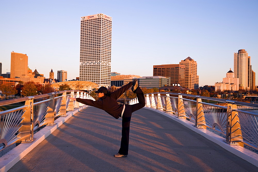 USA, Wisconsin, Milwaukee, Woman doing yoga on bridge in city