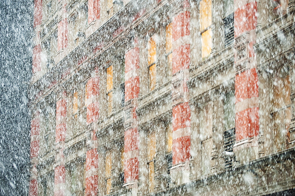 Snow falling in front of apartment building
