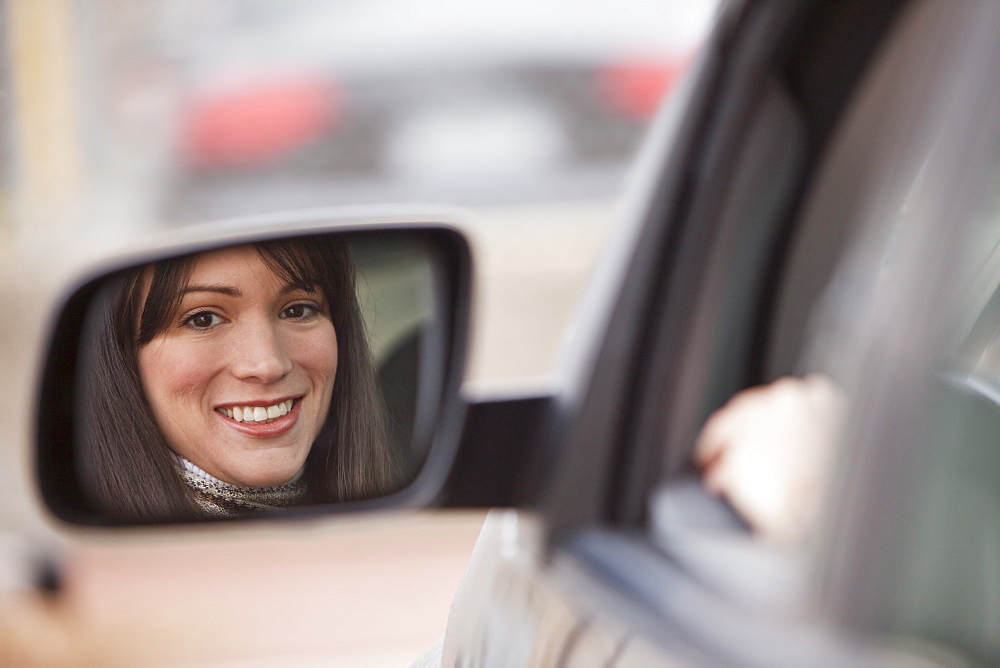 Reflection of woman in side view mirror