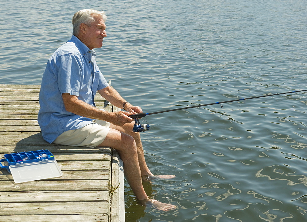 Senior man fishing off dock