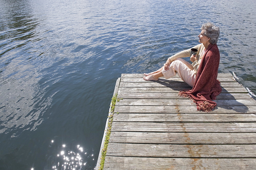 Senior woman sitting on dock