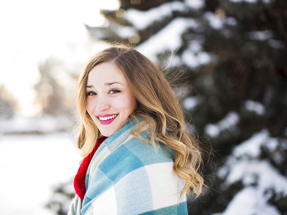 Portrait of woman wrapped in blanket smiling outdoors, Salt Lake City, Utah