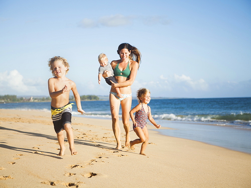Mother with children on beach, Kauai, Hawaii