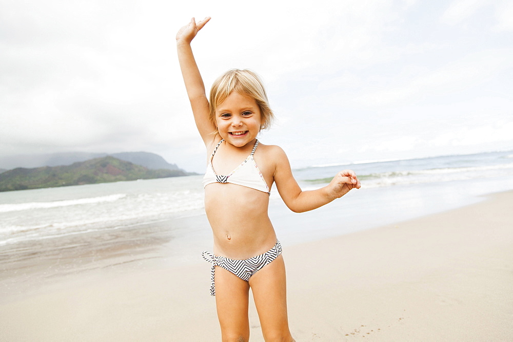 Smiling girl (2-3) on sandy beach, Kauai, Hawaii