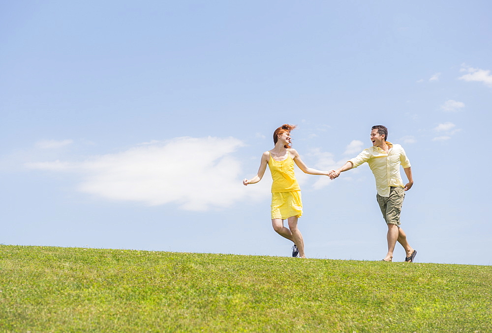 Couple running on meadow, USA, New Jersey, Mendham