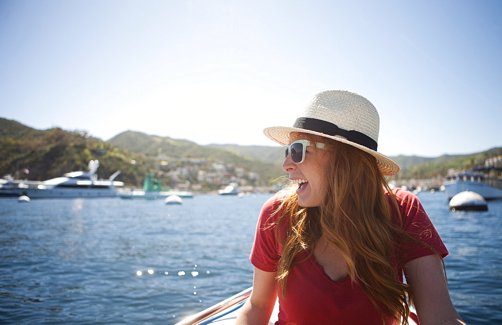 Portrait of young woman in sunglasses and straw hat