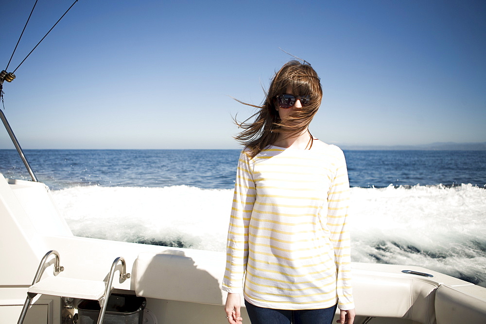 Portrait of young woman in sunglasses in front of sea