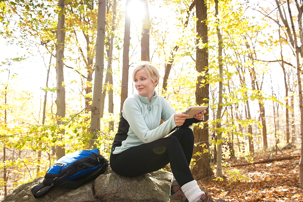 Female hiker using digital tablet in forest