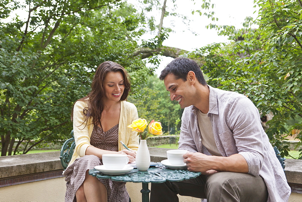 Happy couple sitting at table at outdoor cafe