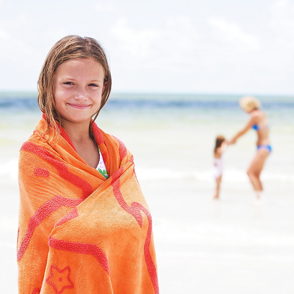 Girl wrapped in towel on beach