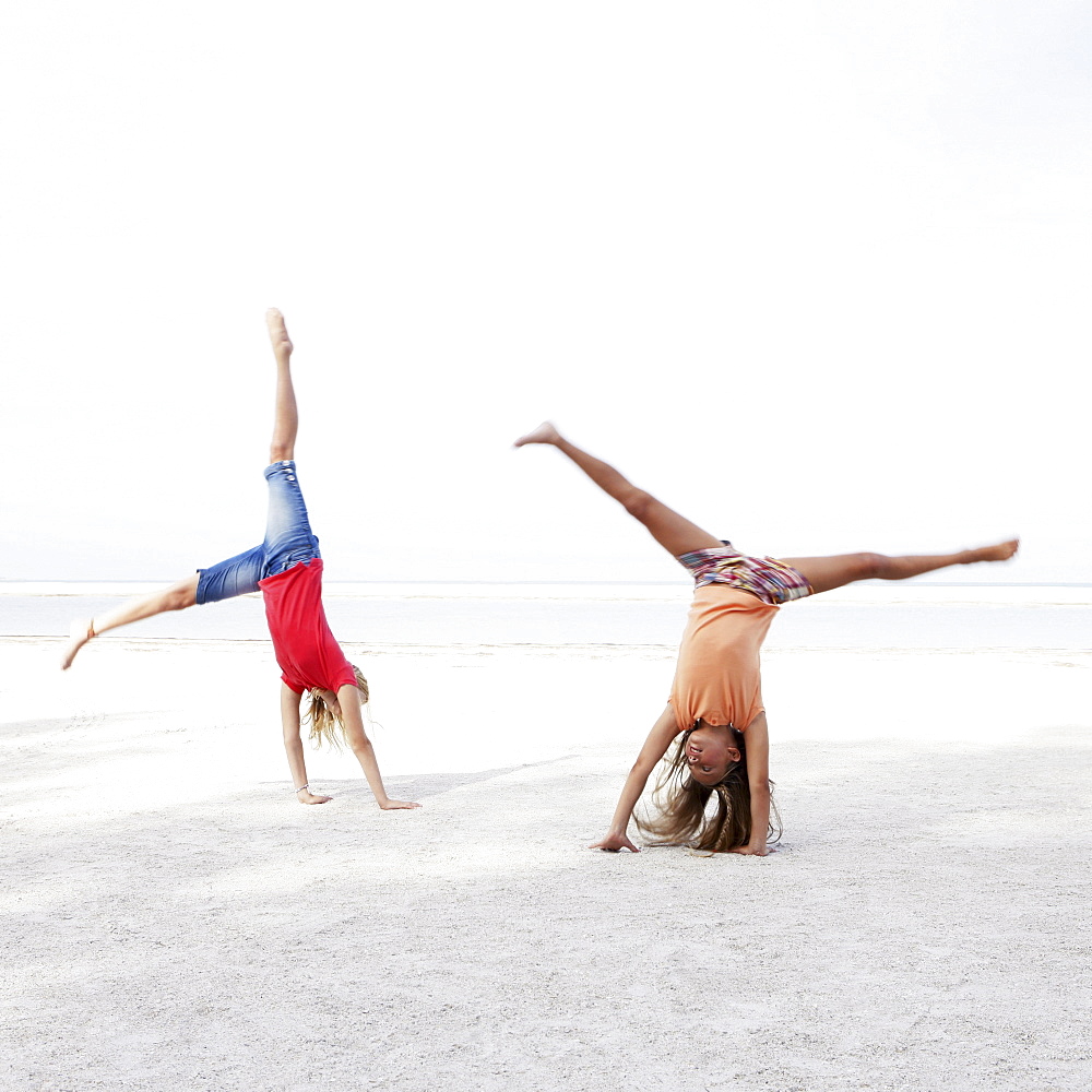 Girls doing cartwheels on beach