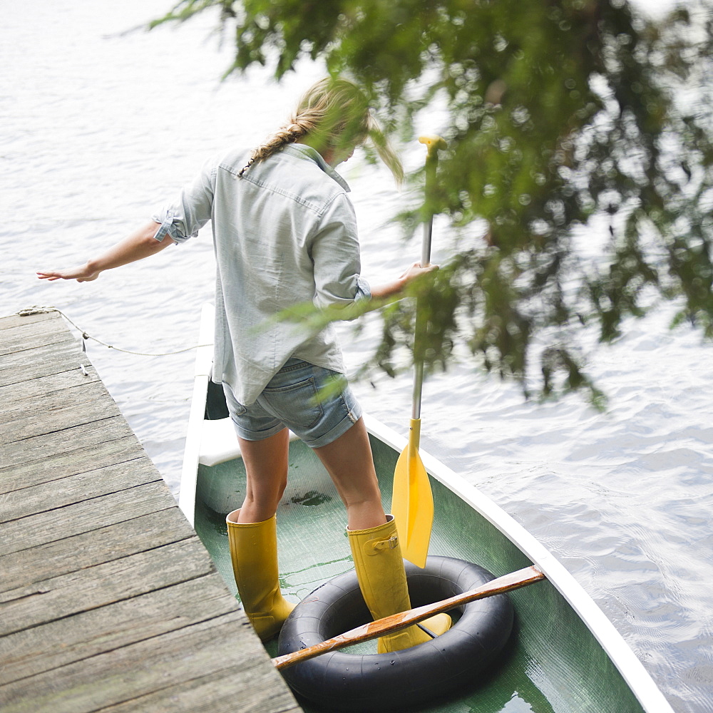 Roaring Brook Lake, Woman standing in boat with paddle