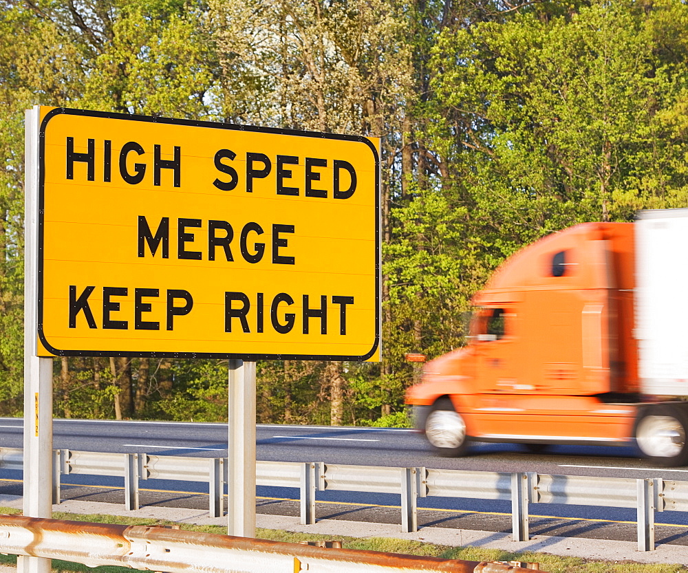 Blurred motion shot of truck driving past street sign