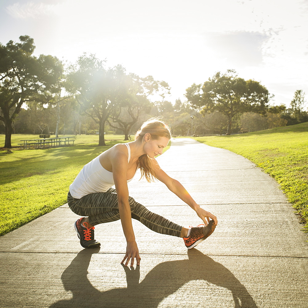 Woman stretching in park, Irvine, California