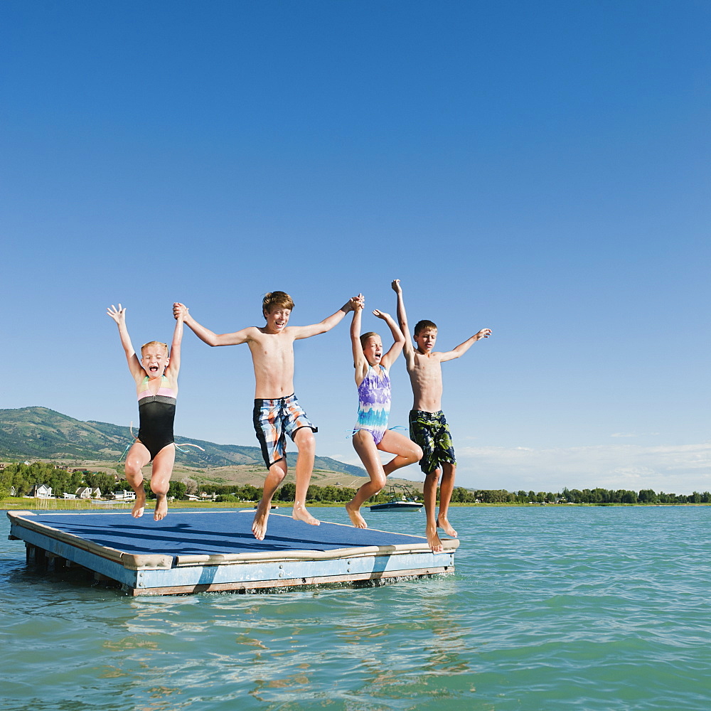 Kids (6-7,8-9,10-11,12-13) playing on raft on lake