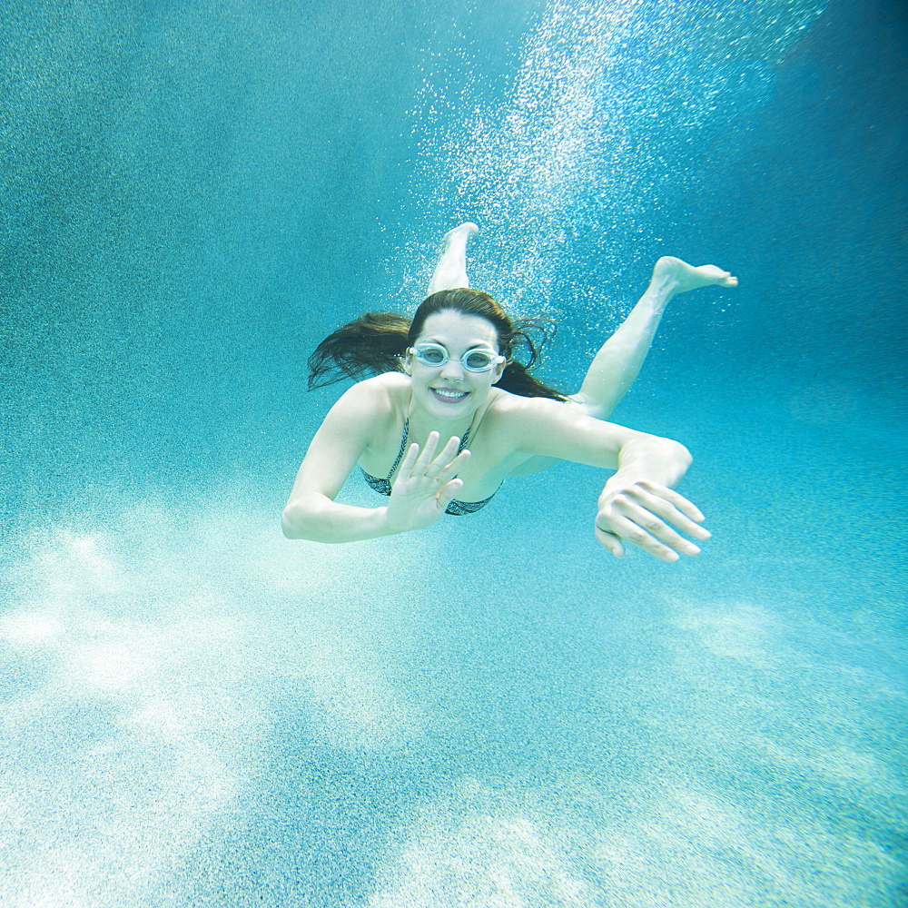 Young attractive woman diving in swimming pool