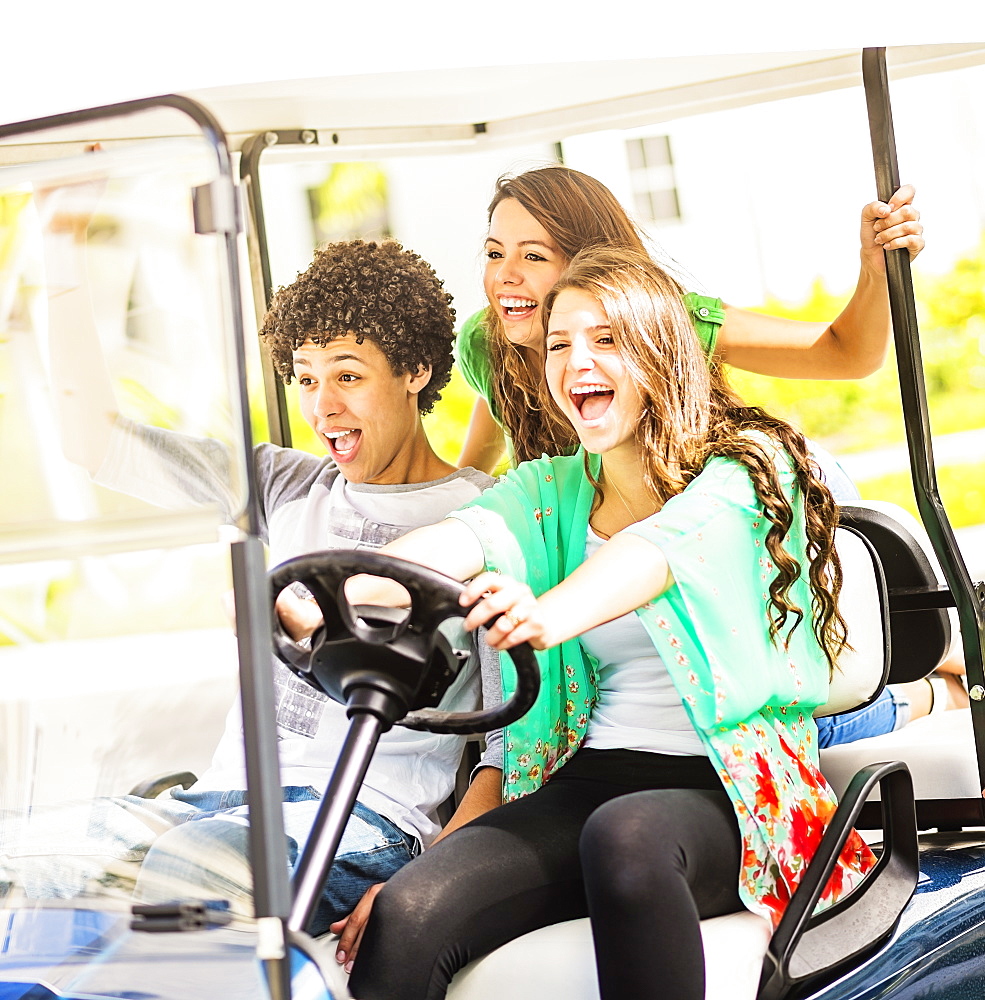 Group of friends (14-15) driving golf cart, Jupiter, Florida