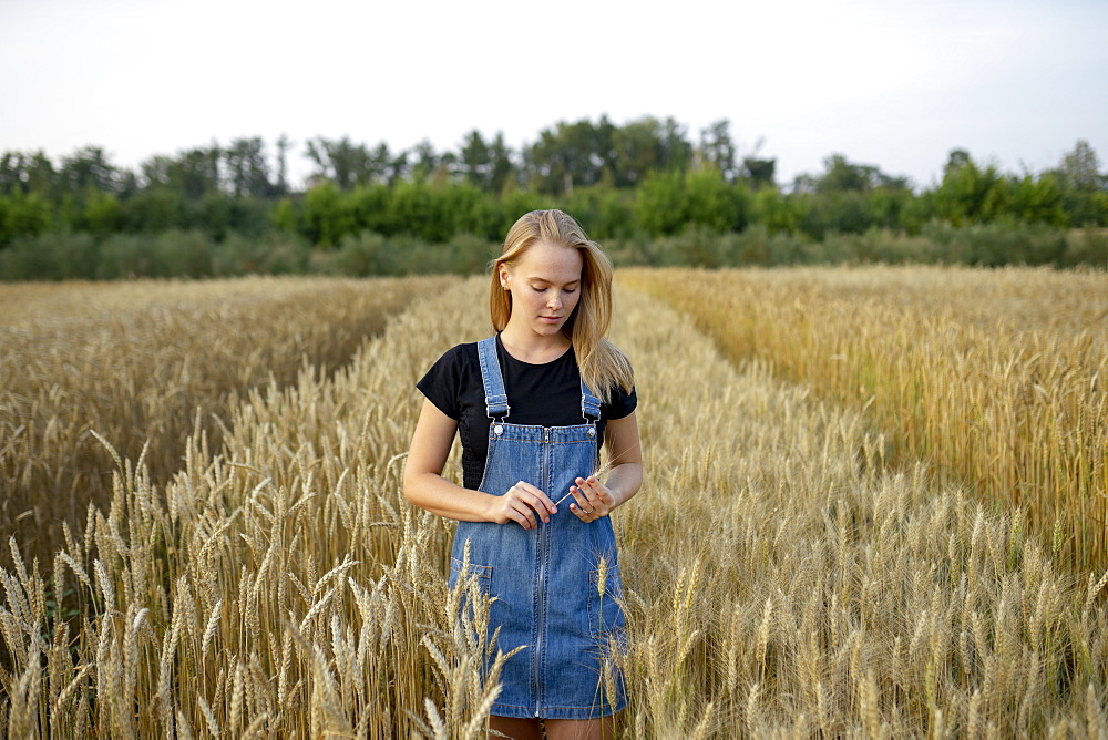 Young woman wearing overall dress in wheat field