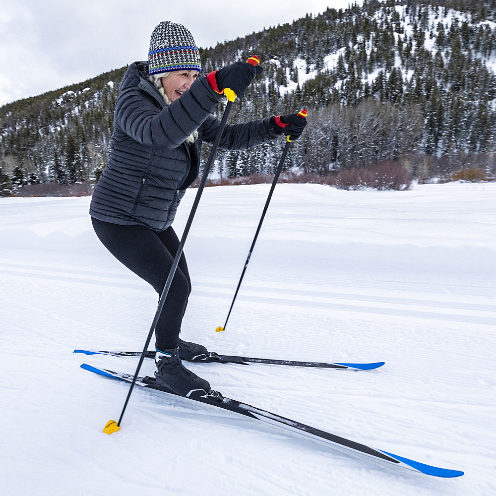 United States, Idaho, sun valley, Senior woman cross - country skiing on groomed trails