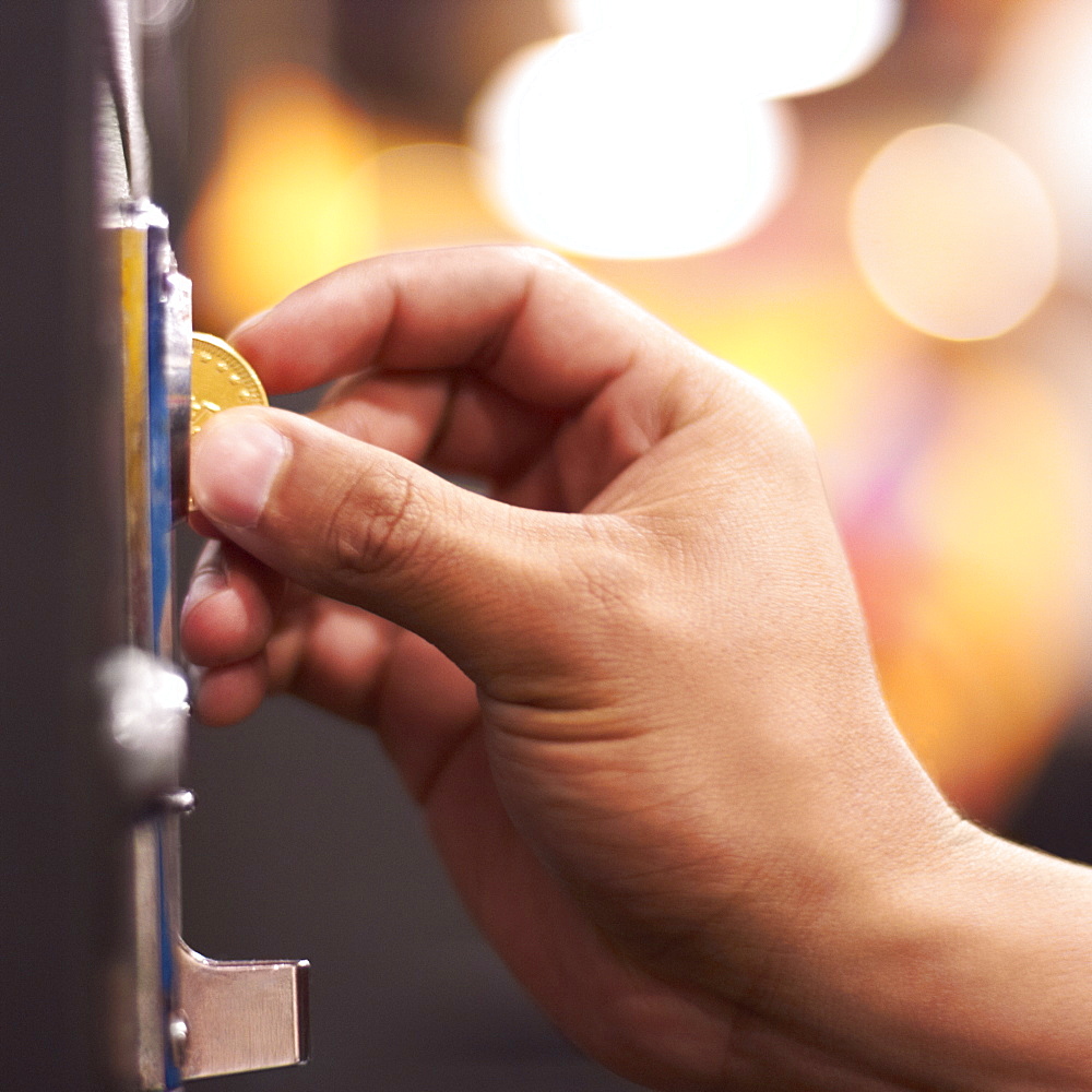 Hand inserting coin into machine