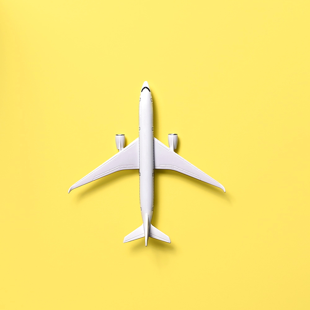 Overhead view of airplane model against yellow background