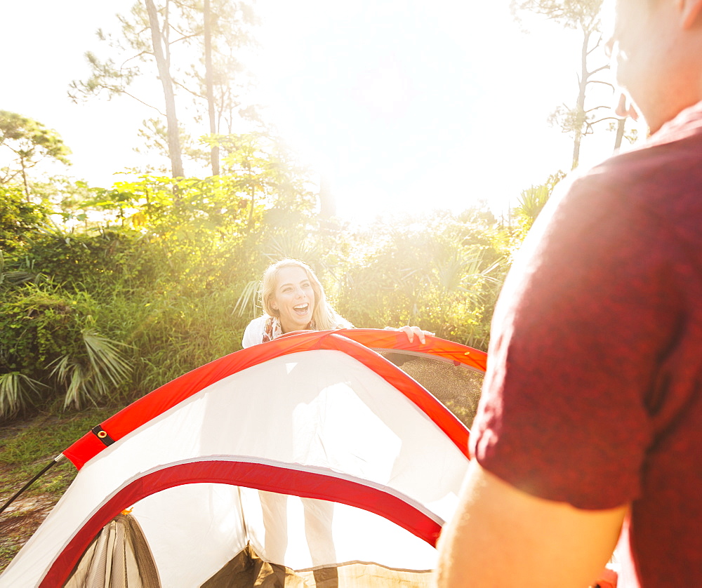 Couple setting up tent in forest, Tequesta, Florida