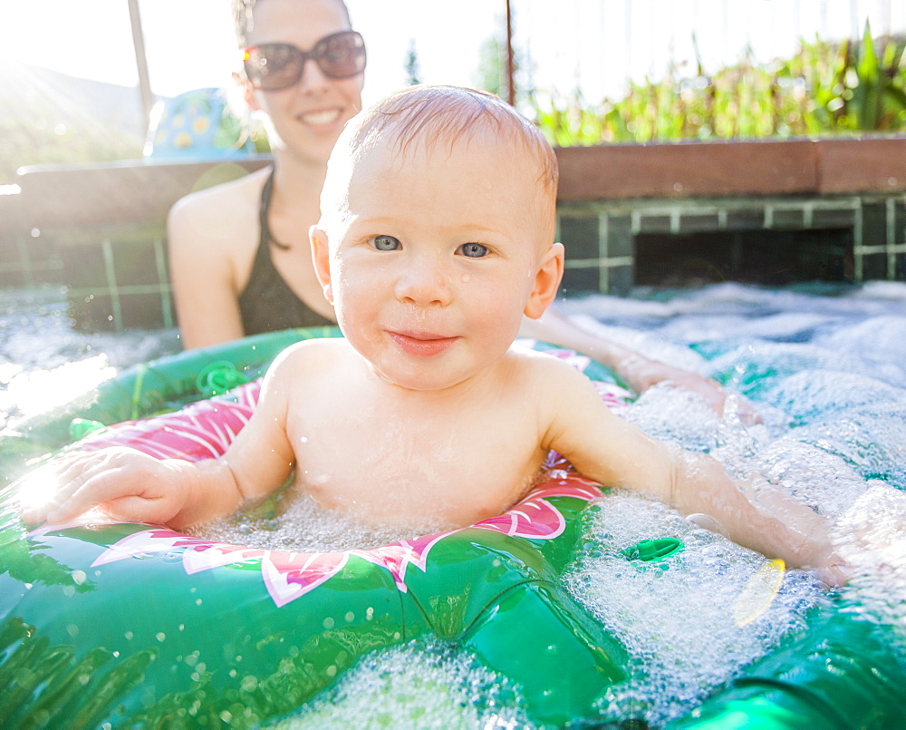 Baby boy (18-23 months) playing in swimming pool with his mother, USA, Utah, Park City 