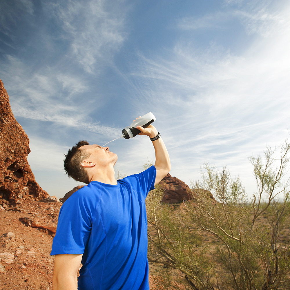  USA, Arizona, Phoenix, Man pouring water on his face