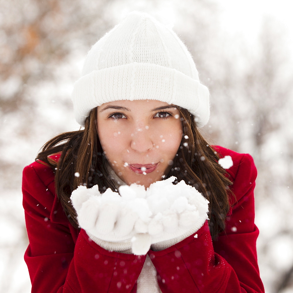 USA, Utah, Lehi, Portrait of young woman blowing snow