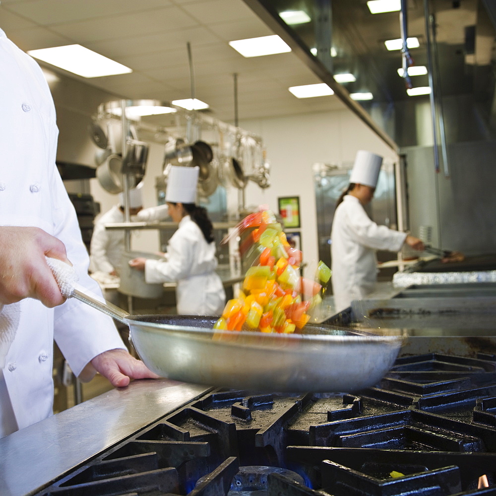 Chef tossing food in skillet