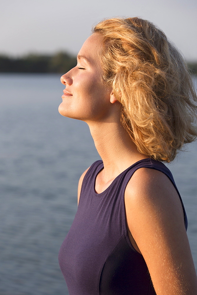 Beautiful woman with closed eyes standing in lake, Netherlands, Gelderland, De Rijkerswoerdse Plassen