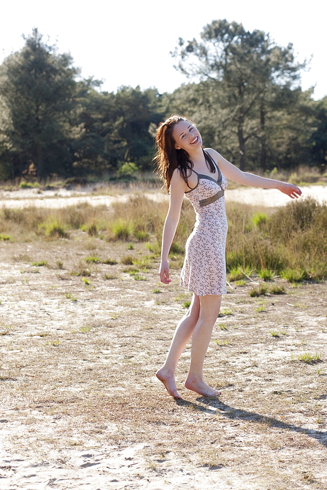 Belgium, Kalmthoutse Heide, Young woman walking barefoot, Kalmthoutse Heide (near Antwerpen), Belgium
