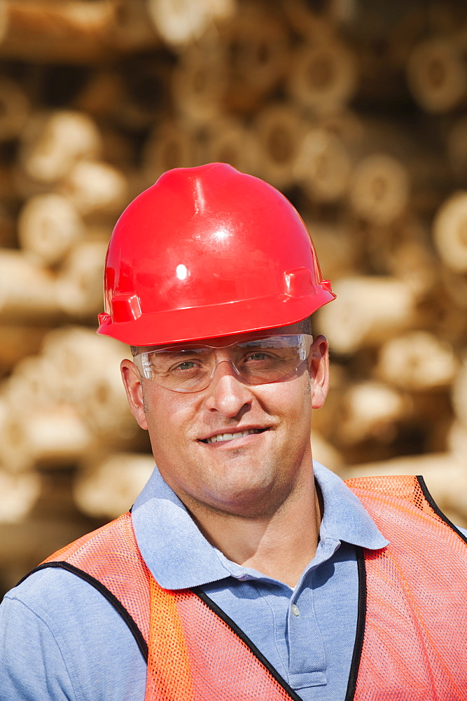 Engineer in front of stack of timber