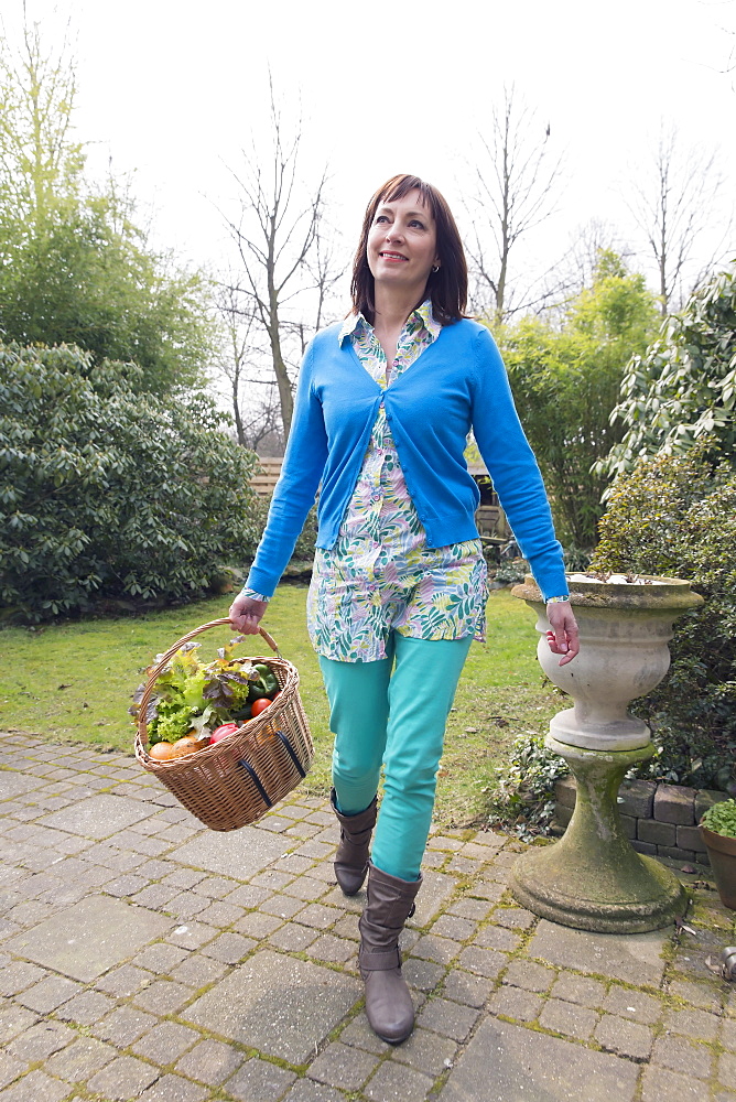 Mature woman with fresh vegetables in basket, Venlo, Netherlands