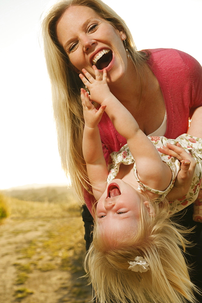 Mother playing with daughter (12-17 months) and laughing