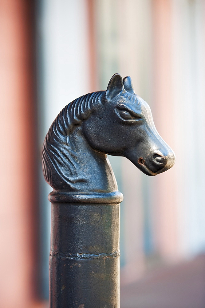 Iron statue of a horse's head on top of a post