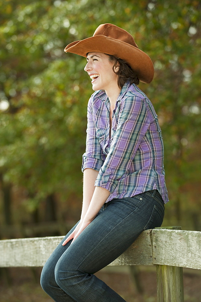 Woman sitting on fence