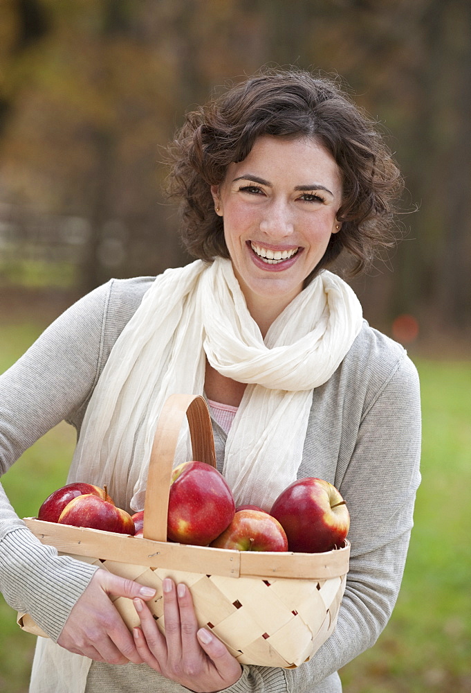 Woman holding basket of apples