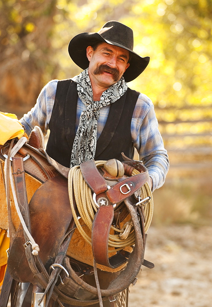 Cowboy holding saddle