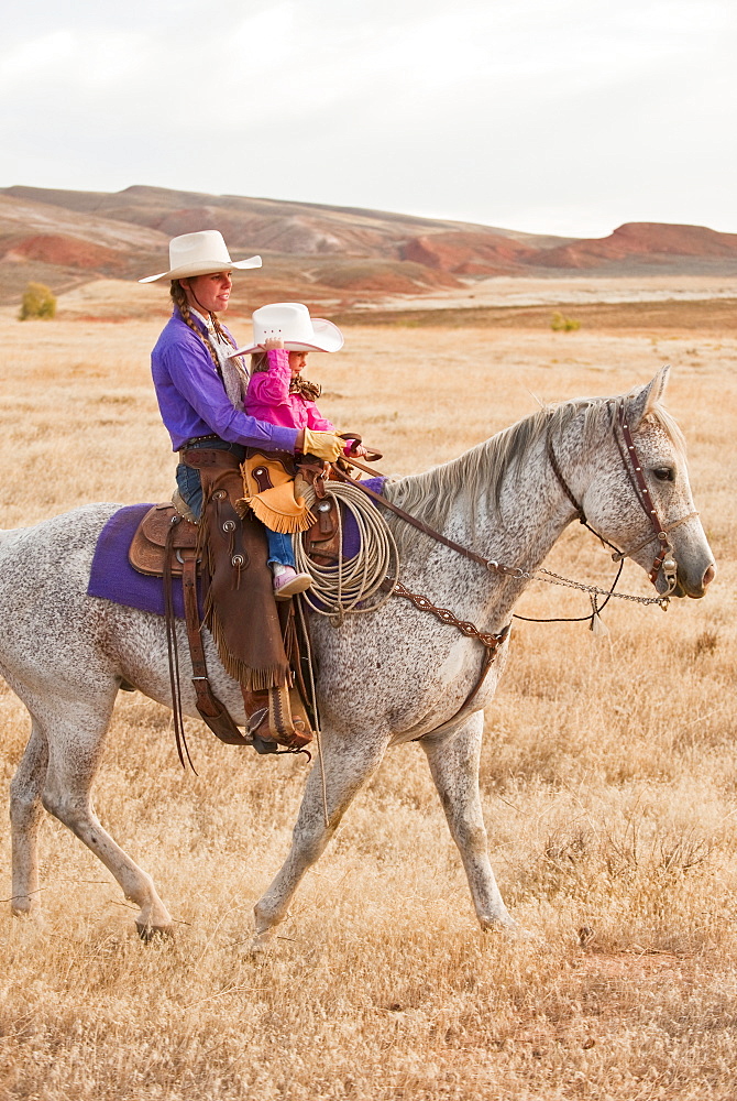 Mother and daughter riding horse