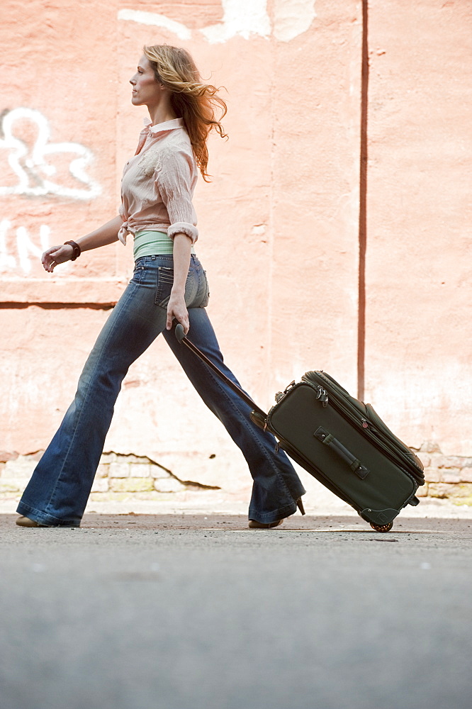 A woman walking with a suitcase