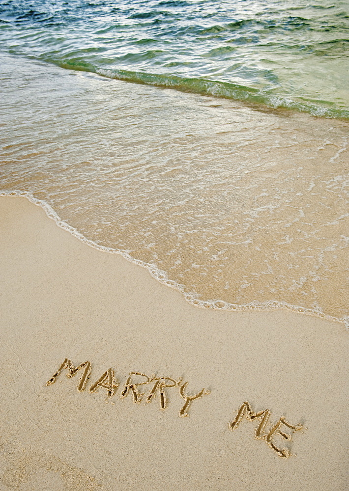 Marry me message written in sand